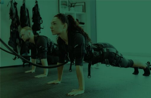 High-energy fitness class focusing on strength and endurance training with women in athletic gear performing push-ups using resistance bands.