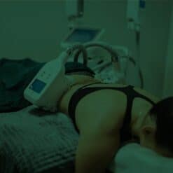 Non-invasive fat reduction treatment being performed on a woman lying on a treatment bed at SLIMM clinic, using advanced body contouring technology for safe weight loss and body shaping, SEO optimized image.